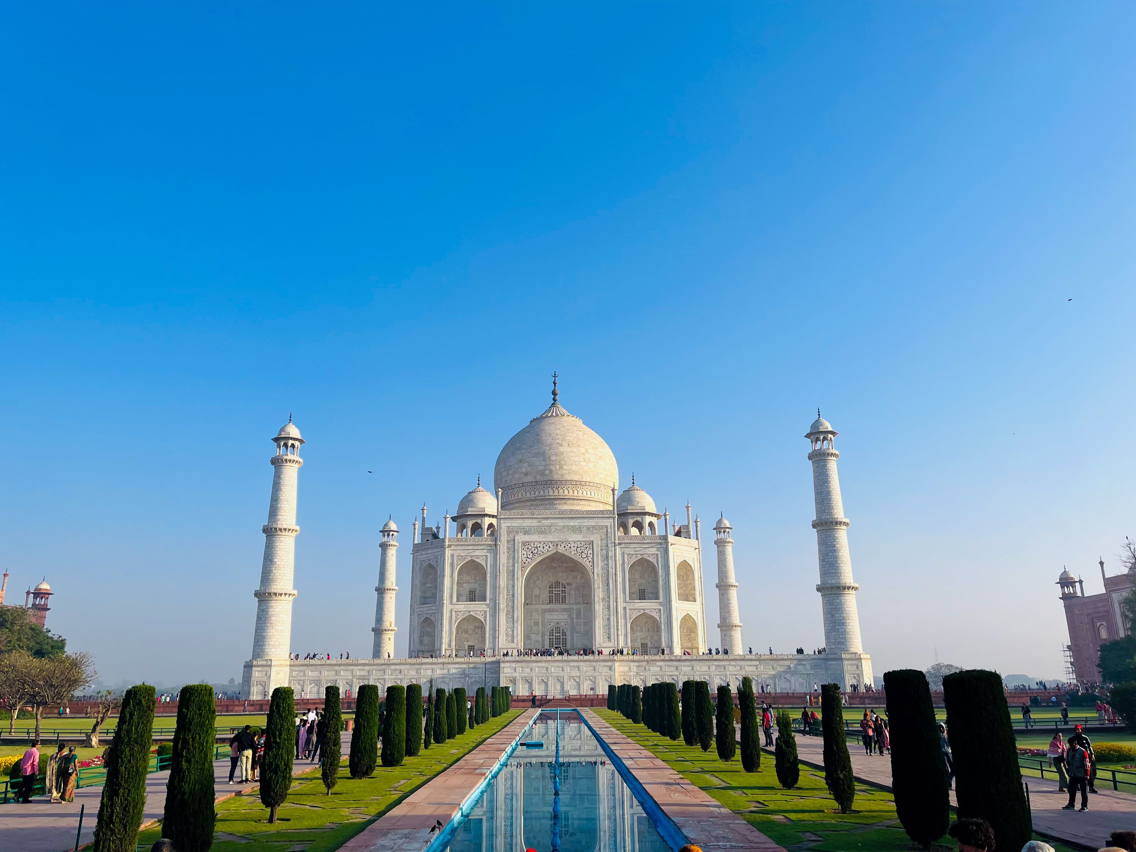 The Taj Mahal's white marble dome reflected in the garden's reflecting pool at sunrise, Agra
