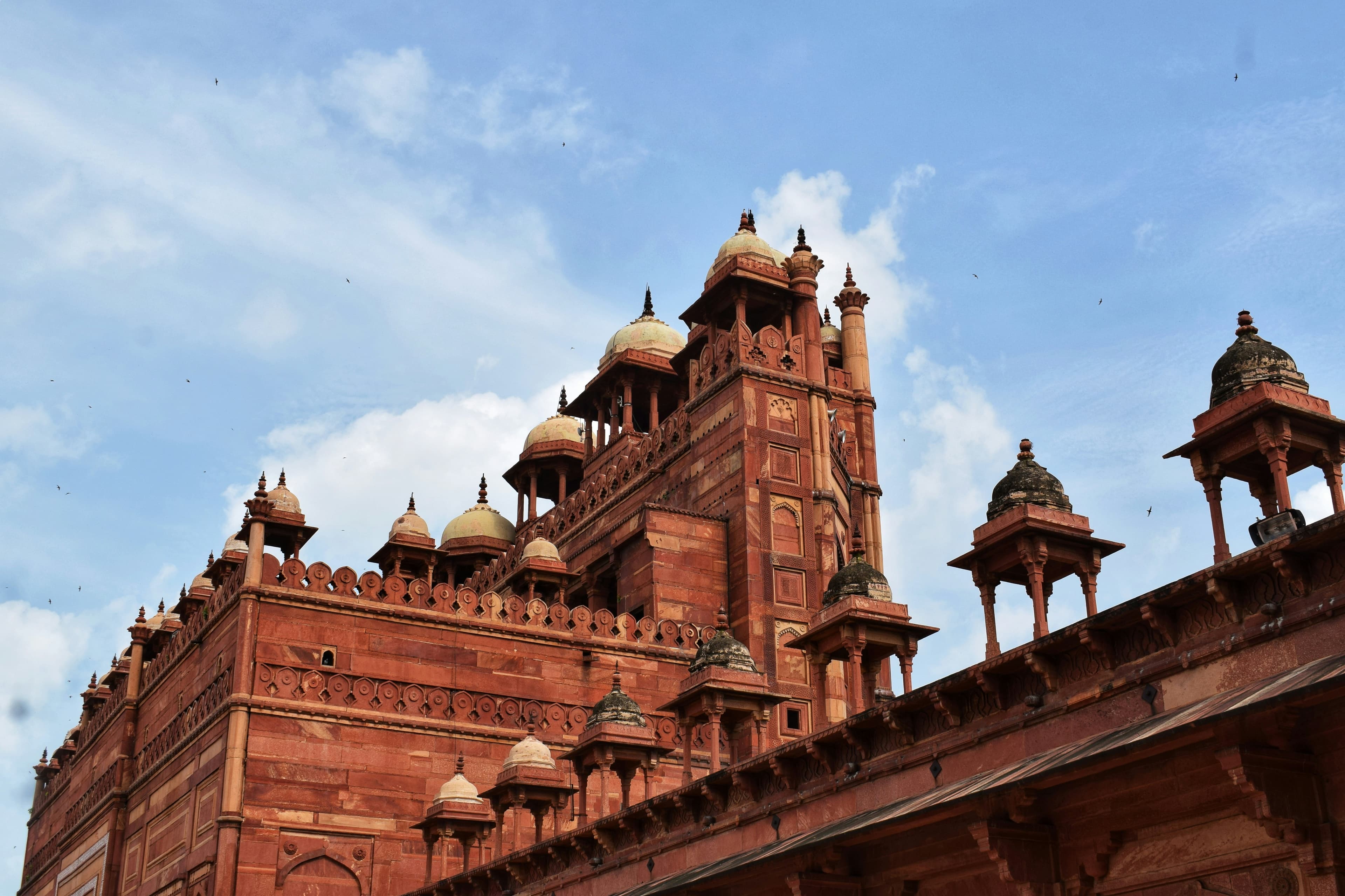 Red sandstone architecture of Fatehpur Sikri with intricate Mughal carvings and arches
