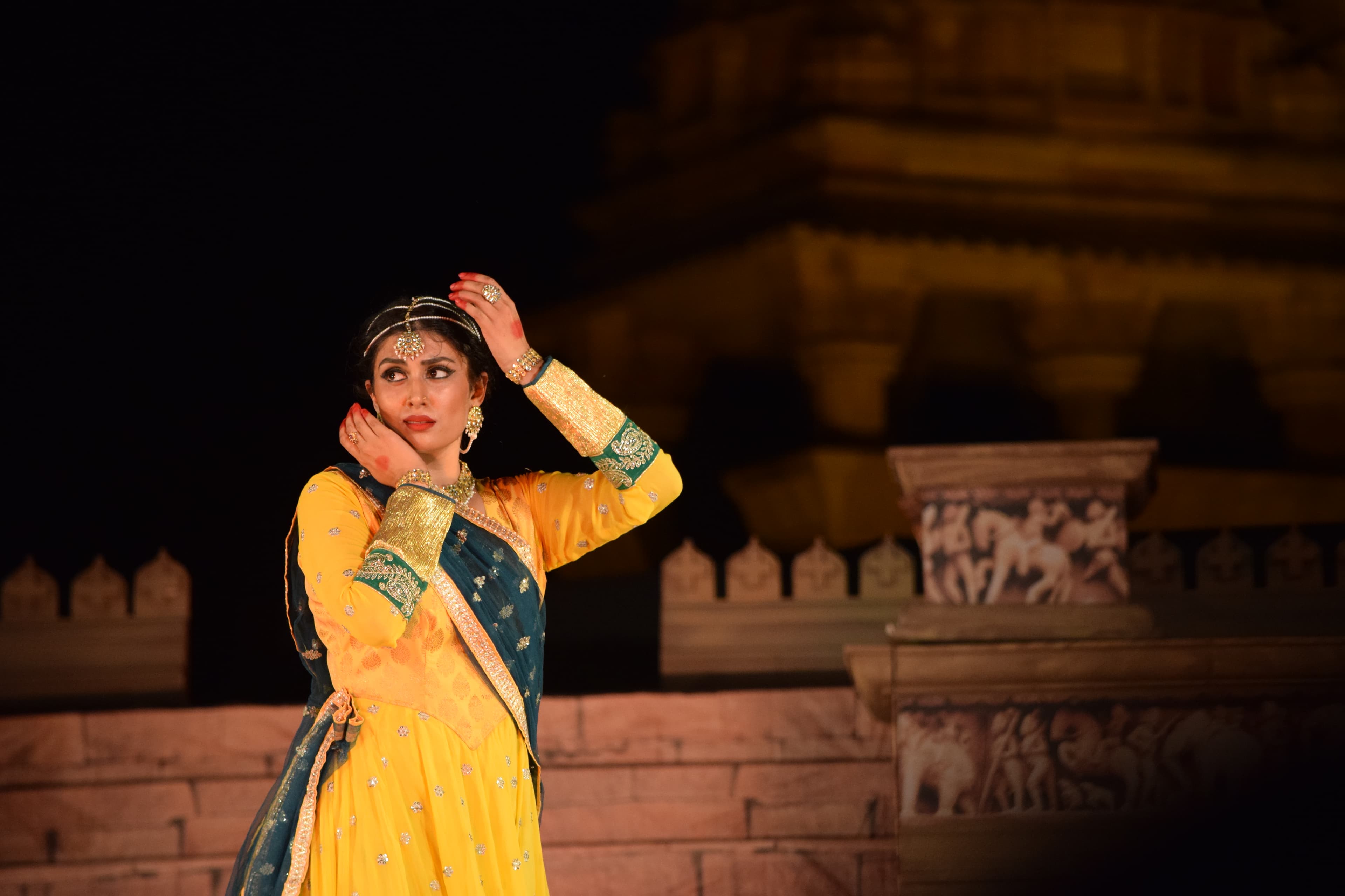 Classical dancers performing during the Khajuraho Dance Festival with illuminated temples in the background